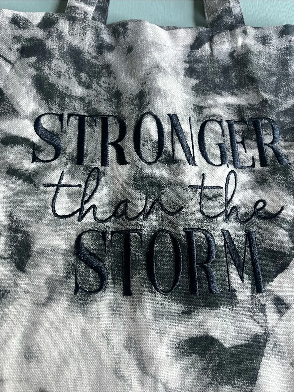 Medium tote bag black and white tie die “Strong than the Storm” on the bag